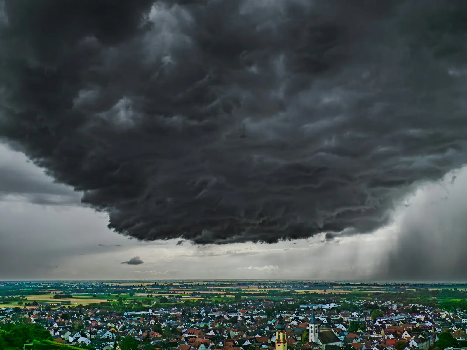 Ciel d’orage très sombre au-dessus d’une plaine habitée